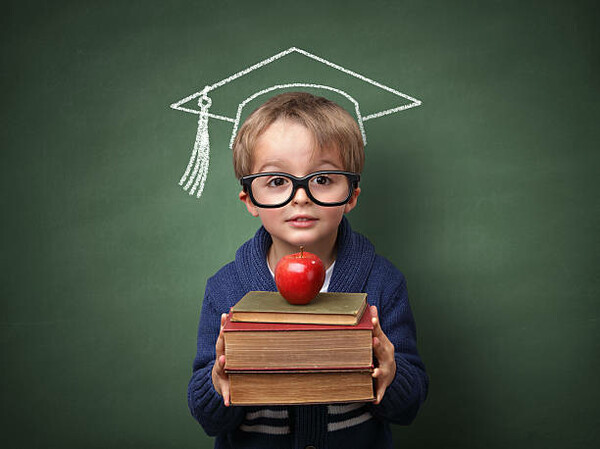 A young student holding books and an apple