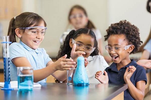 several young students working together on a chemistry experiment