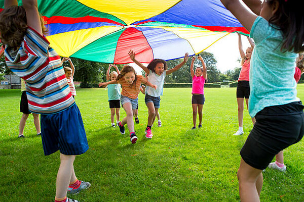 Young children running under a parachute